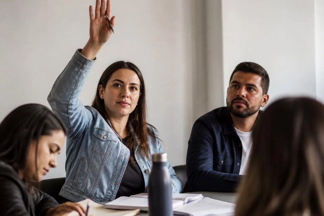 Facilitador em pé apontando para um argumento escrito no quadro durante a sessão